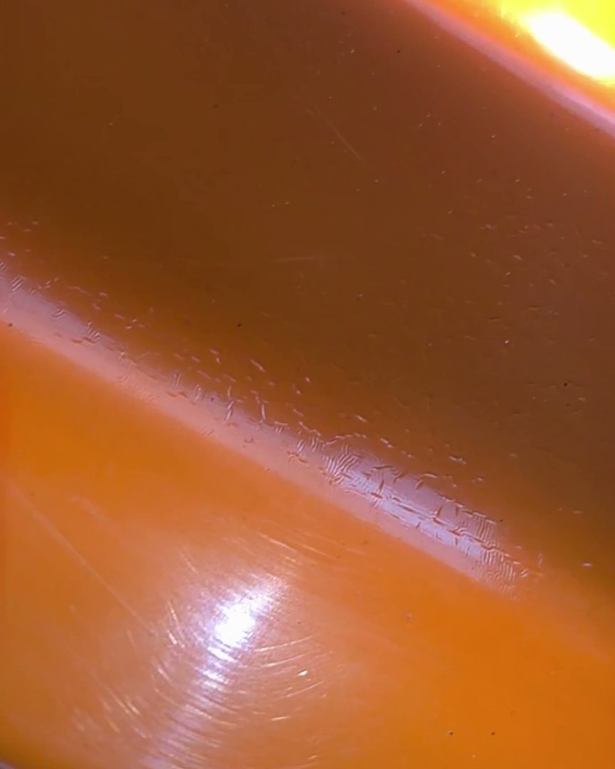 Fine scratches under the clear coat appear in strong, raking light.