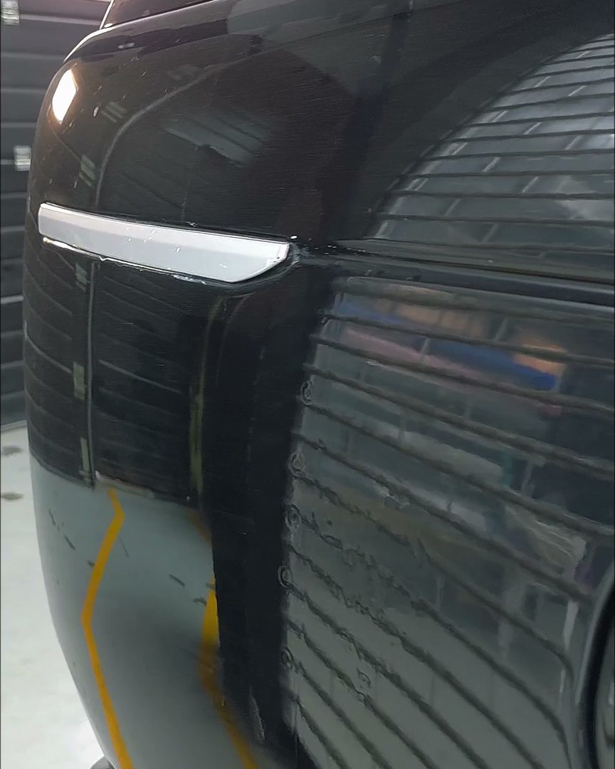 Compare the reflection across adjacent panels: distortion marks a repair.
