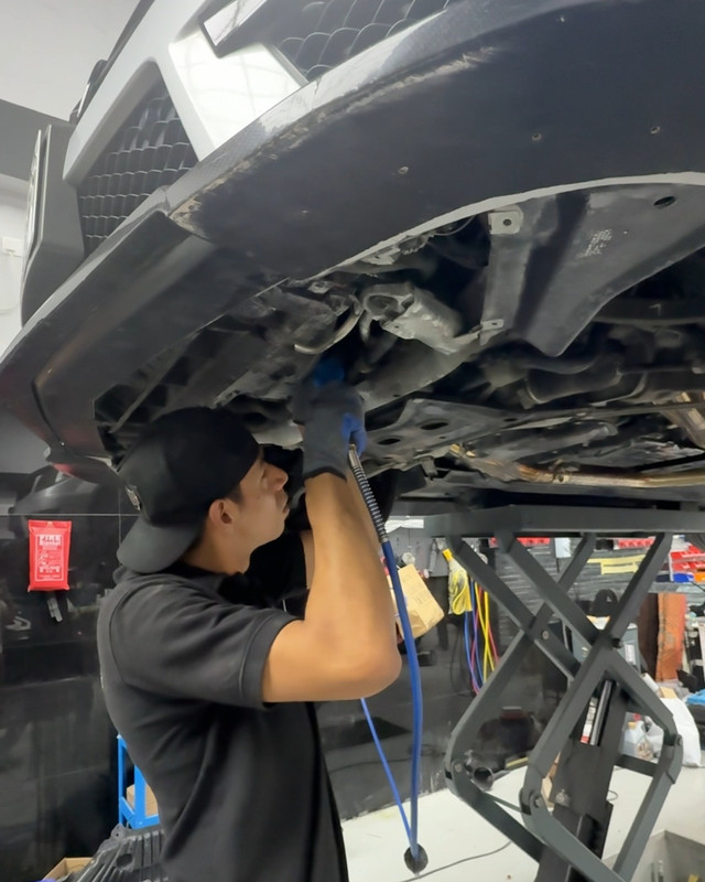 Technician inspecting the underbody on the lift
