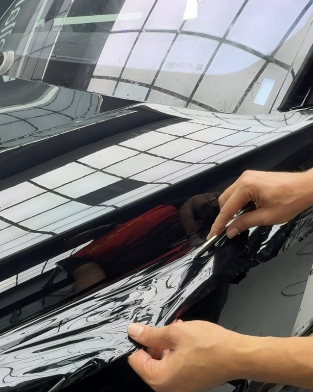 Black vinyl wrap stretched over a panel