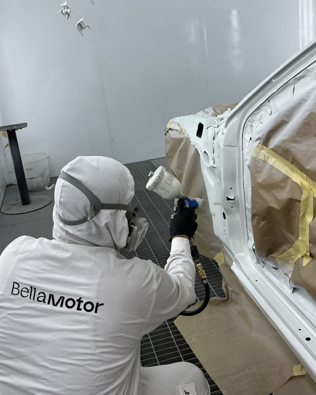 Painter spraying the lower body panel