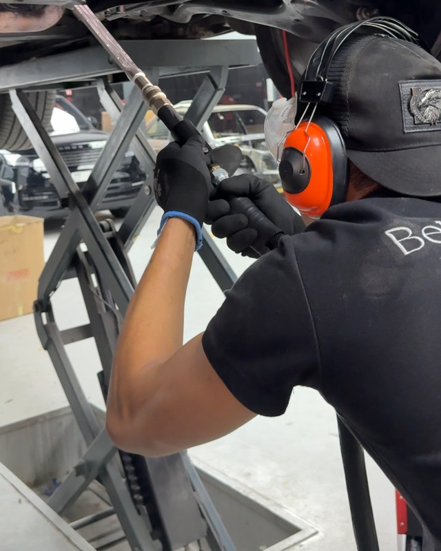 Bella Motor technician working under a car